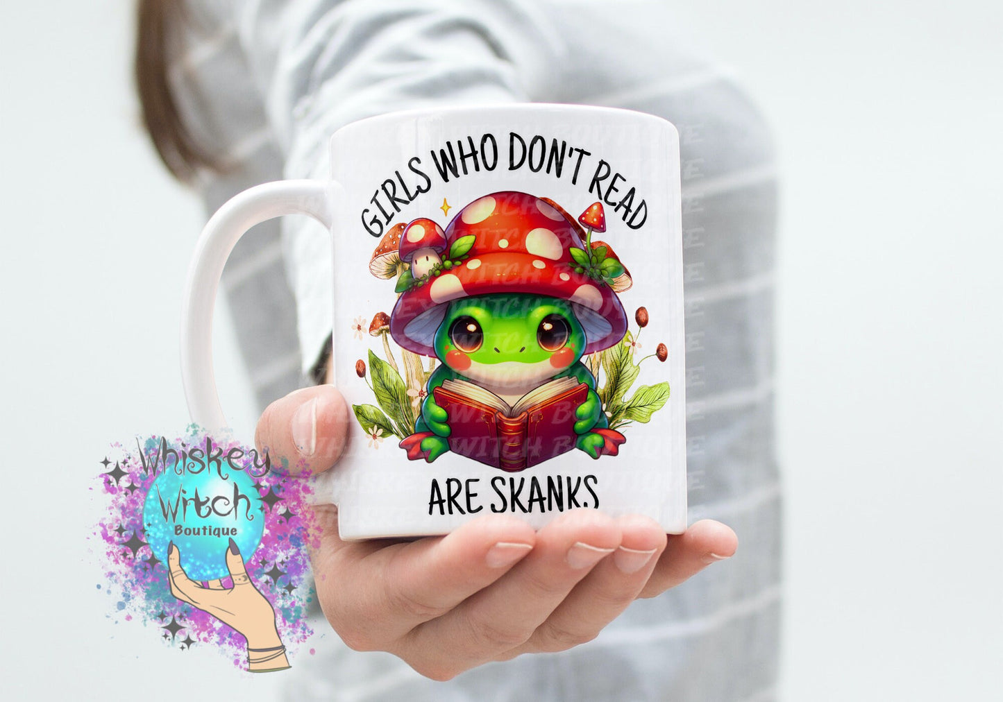 White ceramic mug with kawaii frog reading under red mushroom; bold bookish quote
Close-up of frog and toadstool illustration on funny book lover mug
