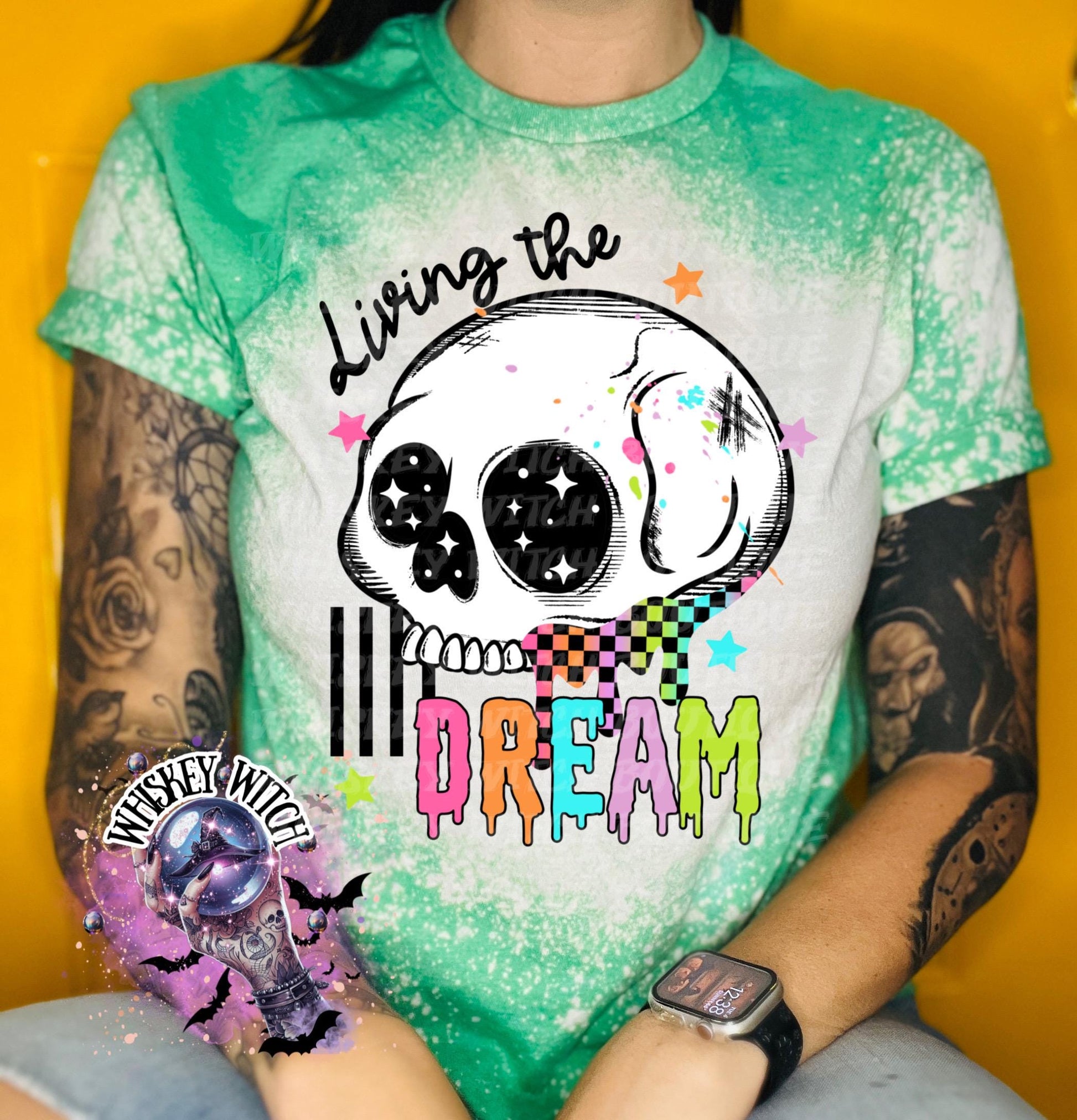 Hand-bleached Irish Green graphic tee featuring a skull illustration, small stars, and the words “Living the Dream” with rainbow drip lettering.