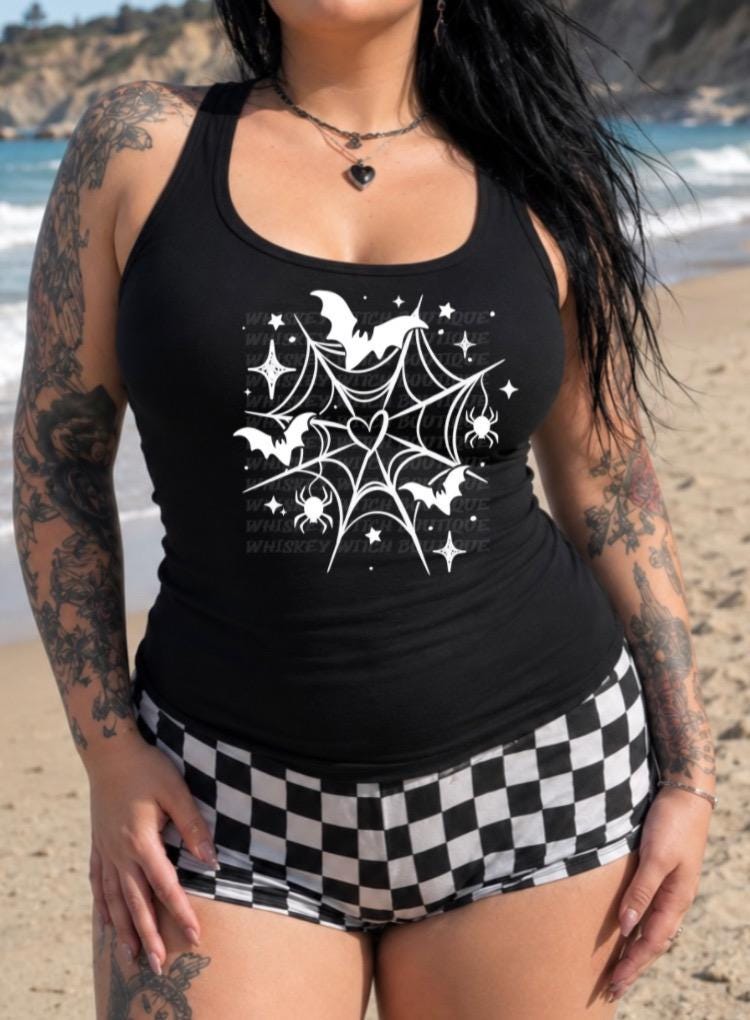 Close-up of white spiderweb and bat artwork on black tank top fabric